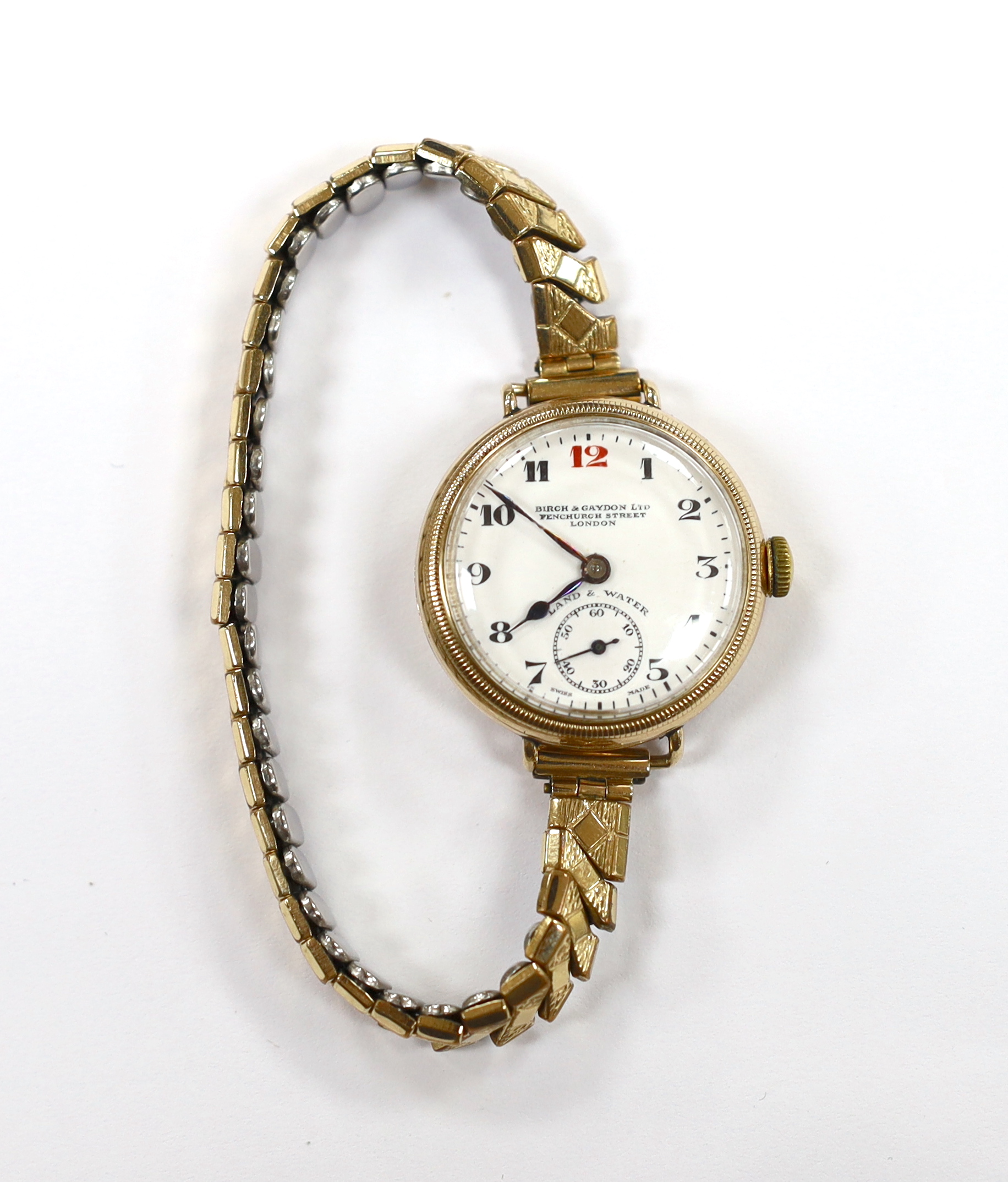 An early 20th century 9ct gold Zenith manual wind wrist watch, retailed by Birch & Gaydon Ltd, London, on a later steel and gold plated flexible strap, case diameter 30mm.